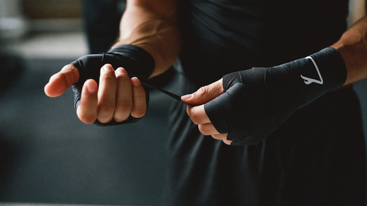 Boxer wrapping hands with black hand wraps before training